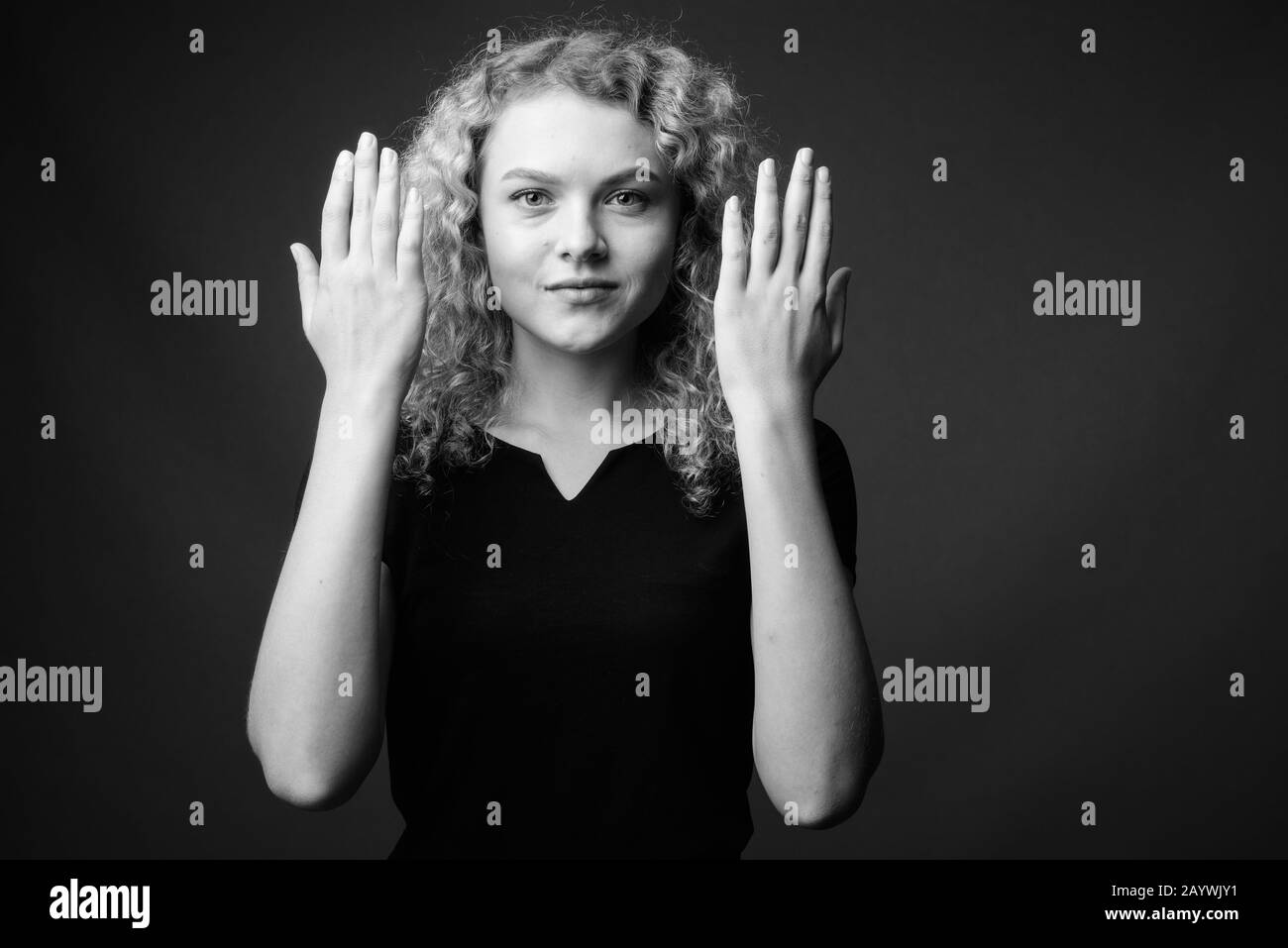 Jeune femme belle avec des cheveux blond frisé sur fond gris Banque D'Images