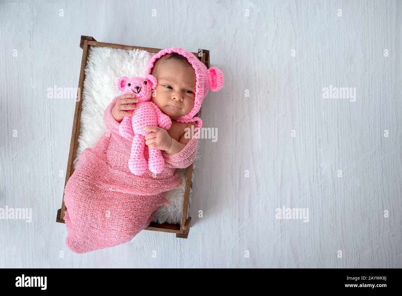 Vue de dessus sur un bébé nouveau-né avec son jouet en peluche dans les mains Banque D'Images