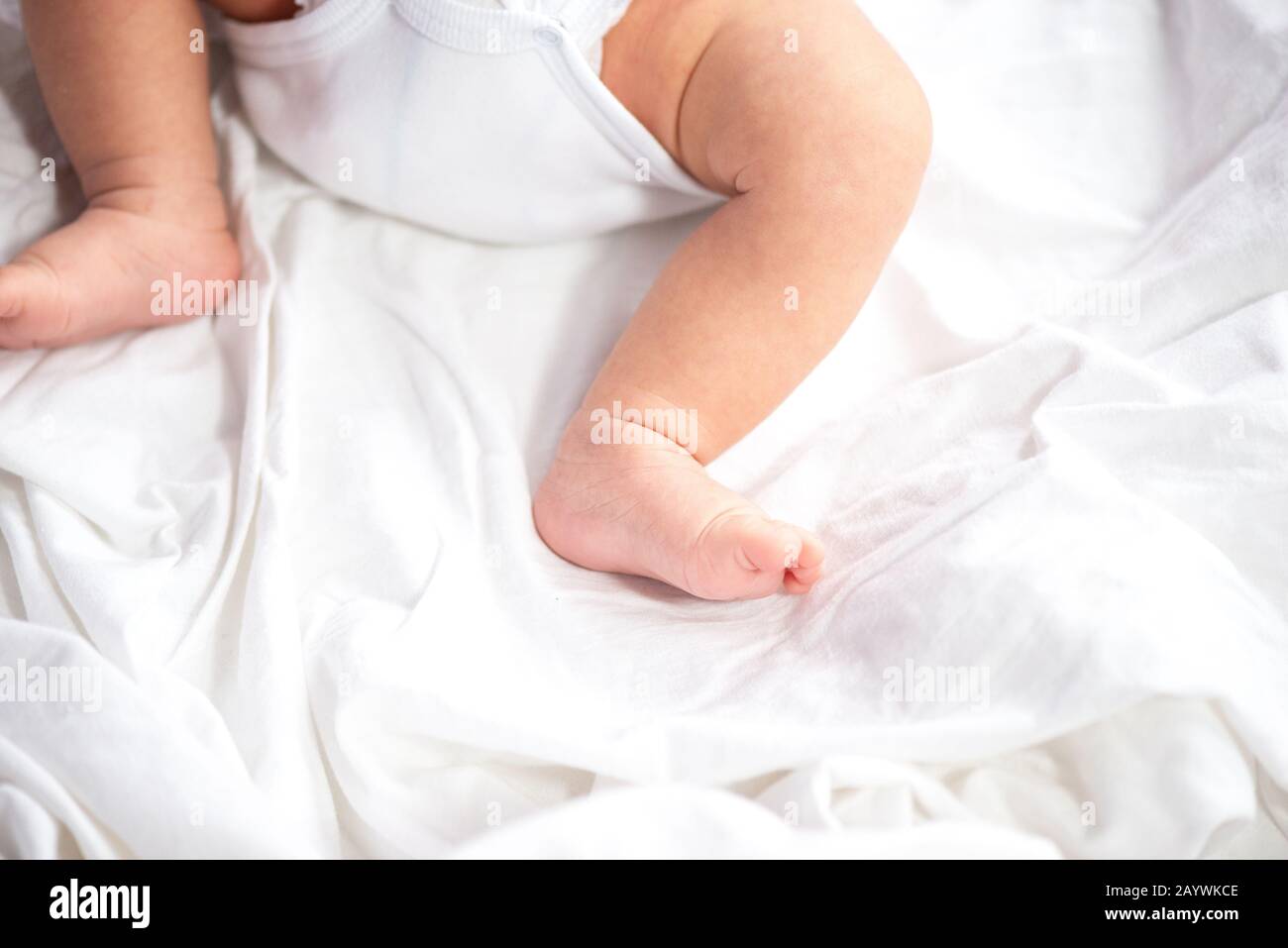 Les jambes de bébé et le bas en couche sur fond de lit blanc, vue du  dessus, copy space Photo Stock - Alamy