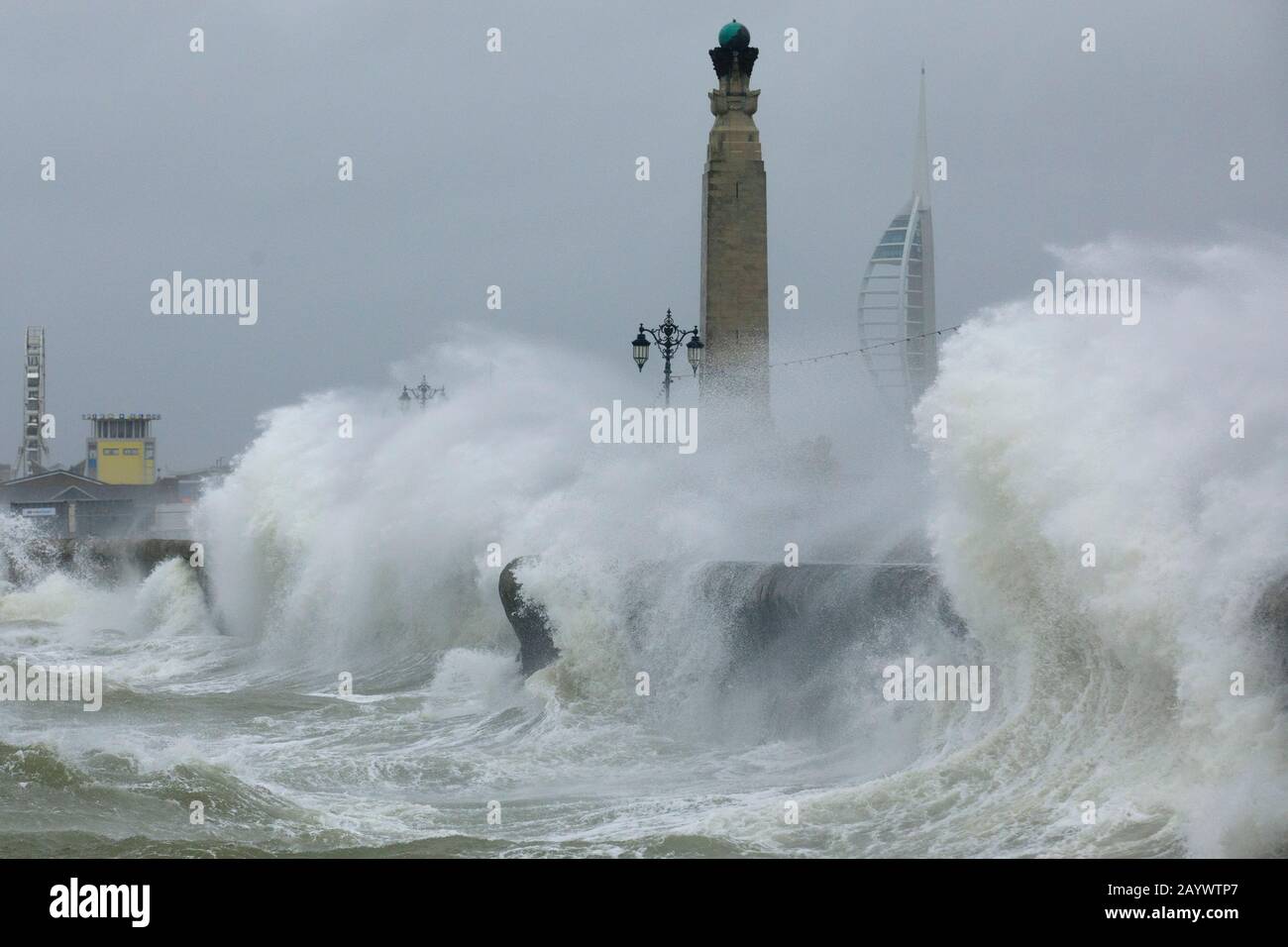 Les vagues s'écrasent contre le mur de la mer près du mémorial de guerre et de la Tour Spinnaker alors que la tempête Dennis propulse la côte à Southsea, Portsmouth, Royaume-Uni le samedi février Banque D'Images