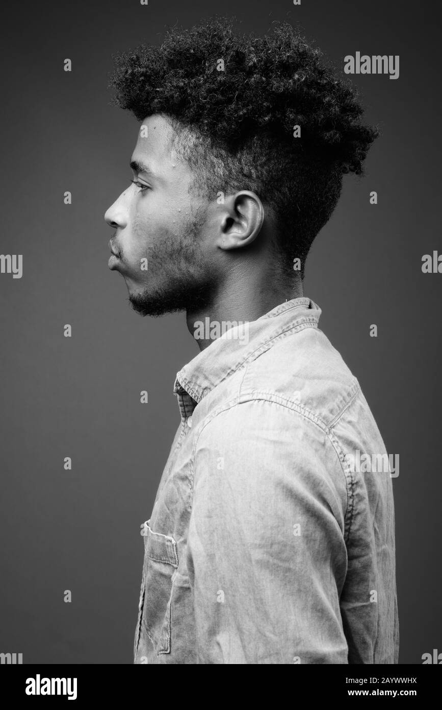 Beau jeune homme africain contre l'arrière-plan gris Banque D'Images