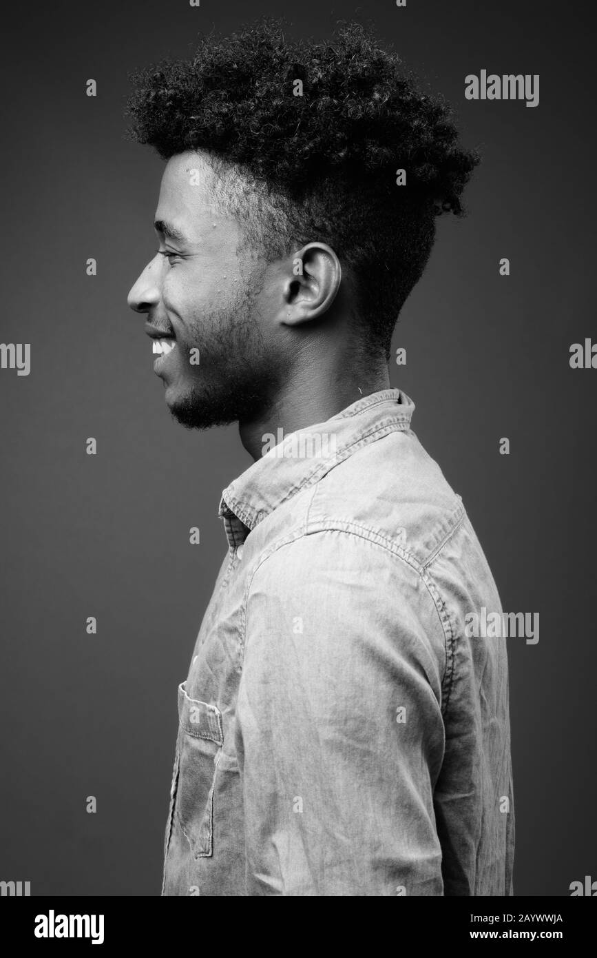 Beau jeune homme africain contre l'arrière-plan gris Banque D'Images