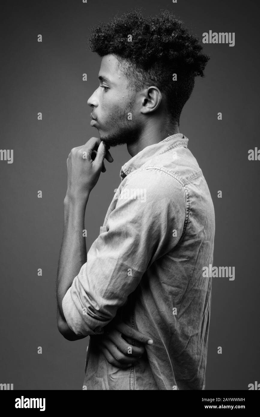 Beau jeune homme africain contre l'arrière-plan gris Banque D'Images