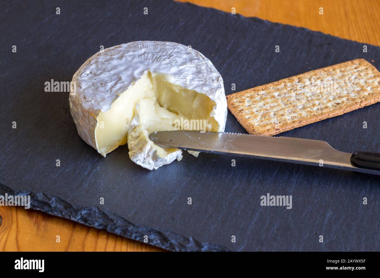 Fromage Camembert et craqueur de blé entier à la planche à fromage d'ardoise noire Banque D'Images
