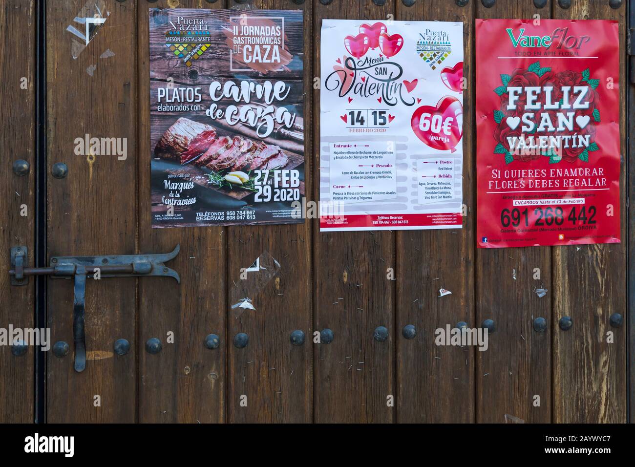 Affiches, y compris les annonces de Saint-Valentin, sur porte en bois à Pampaneira, Andalousie, Espagne en février Banque D'Images