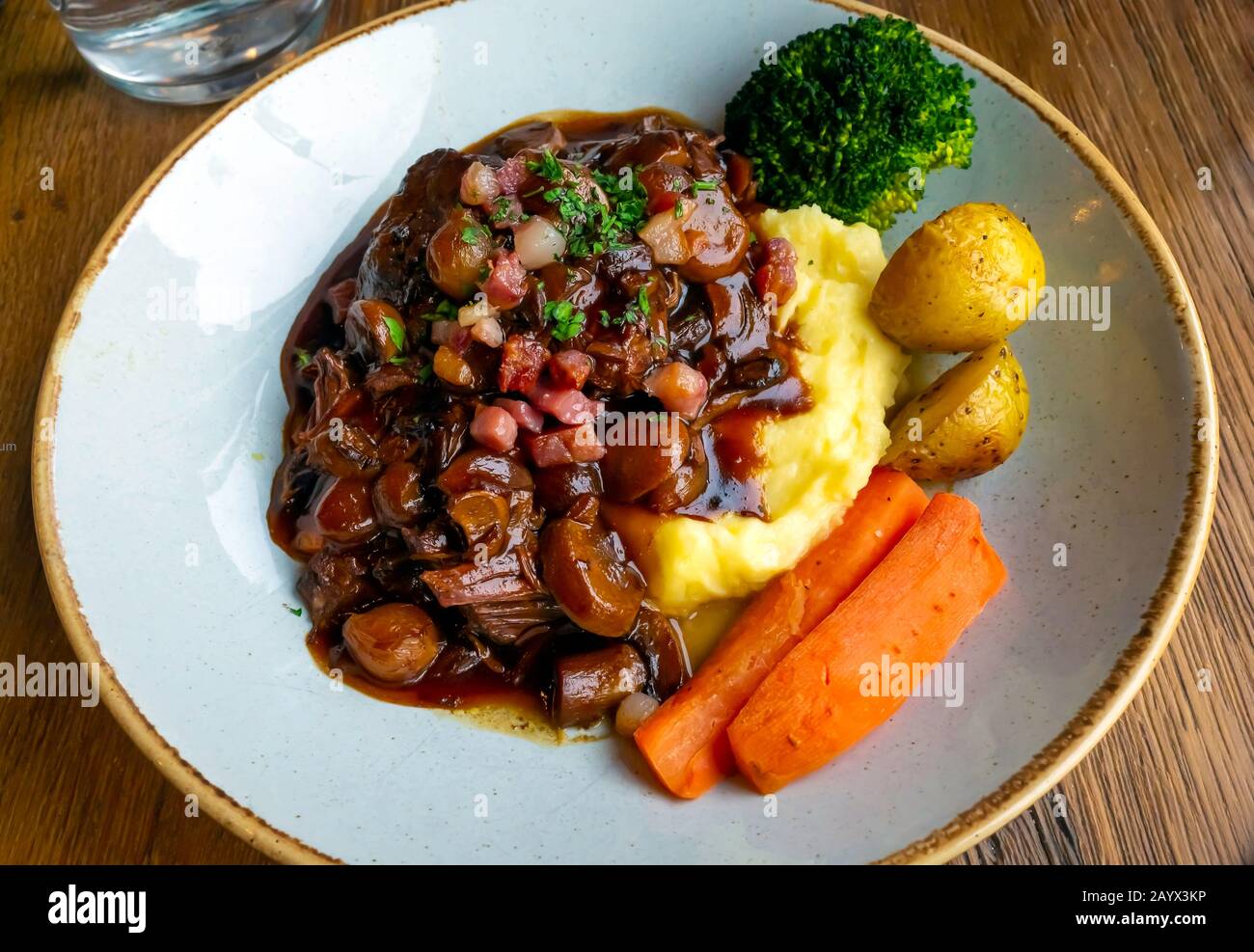 Déjeuner au café un plat de bœuf bourguignon avec purée et de nouvelles carottes de pommes de terre et brocolli dans un restaurant de style français Banque D'Images
