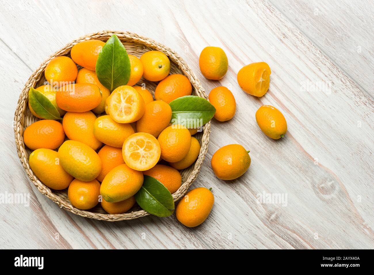 Kumquat fruits dans le panier sur table en bois. Banque D'Images