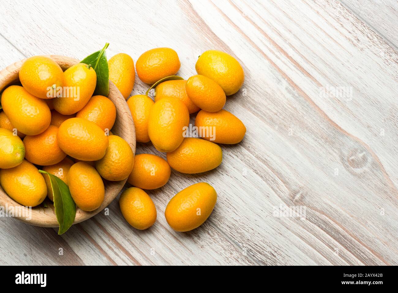 Kumquat fruits dans un bol sur table en bois. Banque D'Images