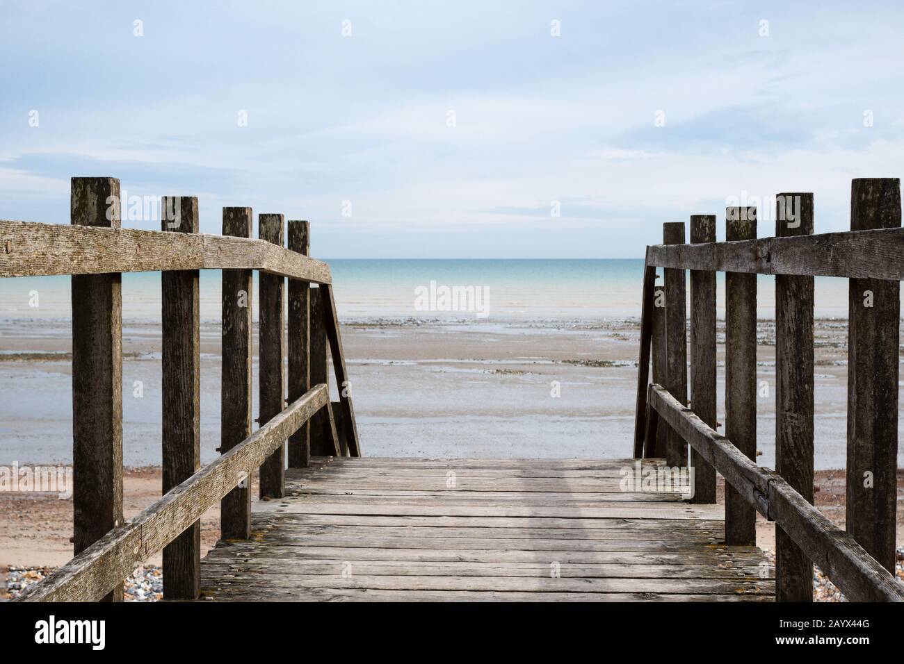 Prise de vue du point de vue sur un pont en bois, en regardant vers l'horizon à la plage à marée basse. Banque D'Images