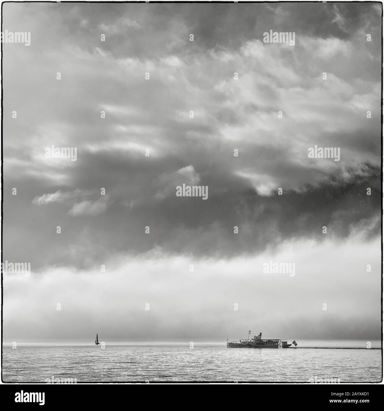 Steamboat Blüemlisalp et un bateau à voile naviguant à la journée du nouvel an sur le lac Thun. (Noir Et Blanc) Banque D'Images