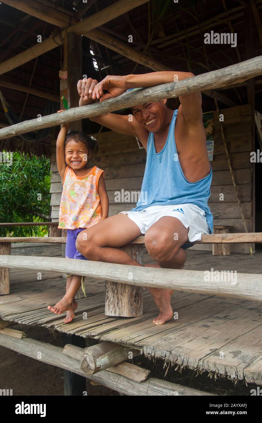 Père et fille dans une maison sur pilotis dans un village le long de la rivière Maranon dans le bassin de la rivière Amazone péruvienne près d'Iquitos. Banque D'Images