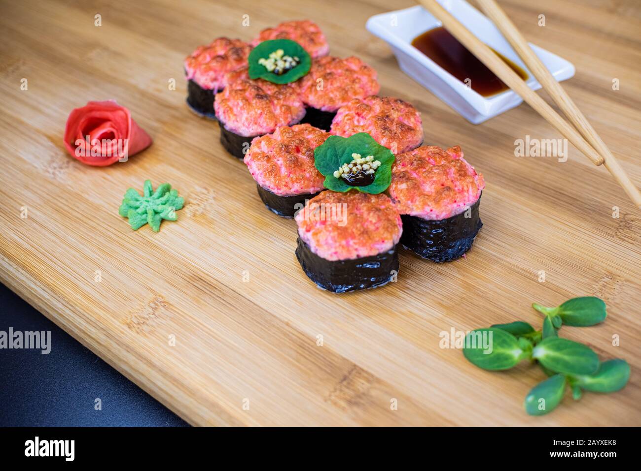 Les sushis japonais sont servis sur une planche en bois. Saumon, riz, wasabi, gingembre, baguettes la cuisine japonaise Hashi. Sauce soja Banque D'Images