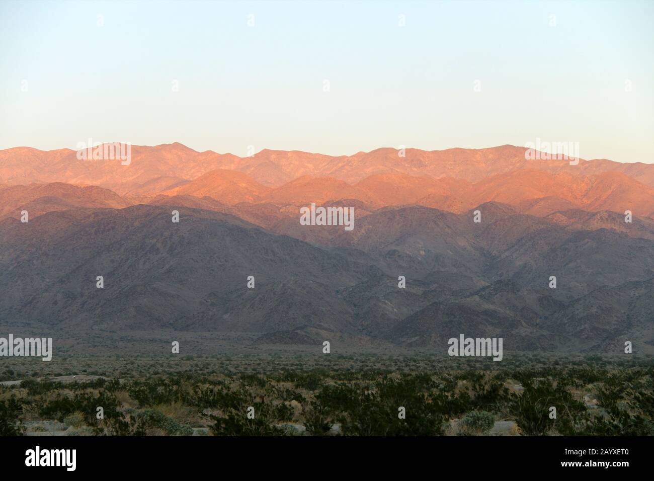 un coucher de soleil contre les montagnes du désert avec des ombres profondes lumineuses Banque D'Images
