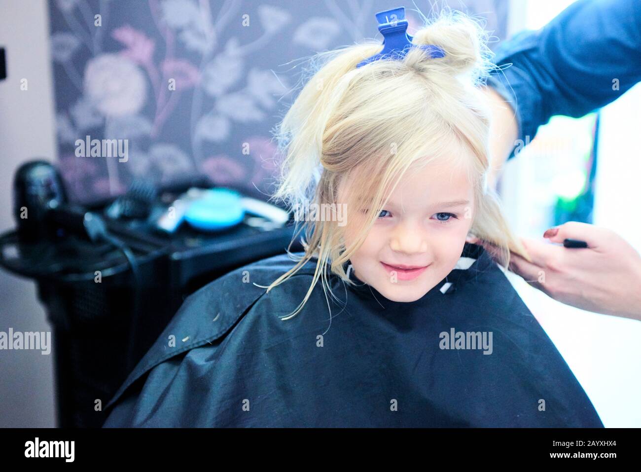 Petite fille mignonne dans le salon de coiffure. Mise au point sélective Banque D'Images