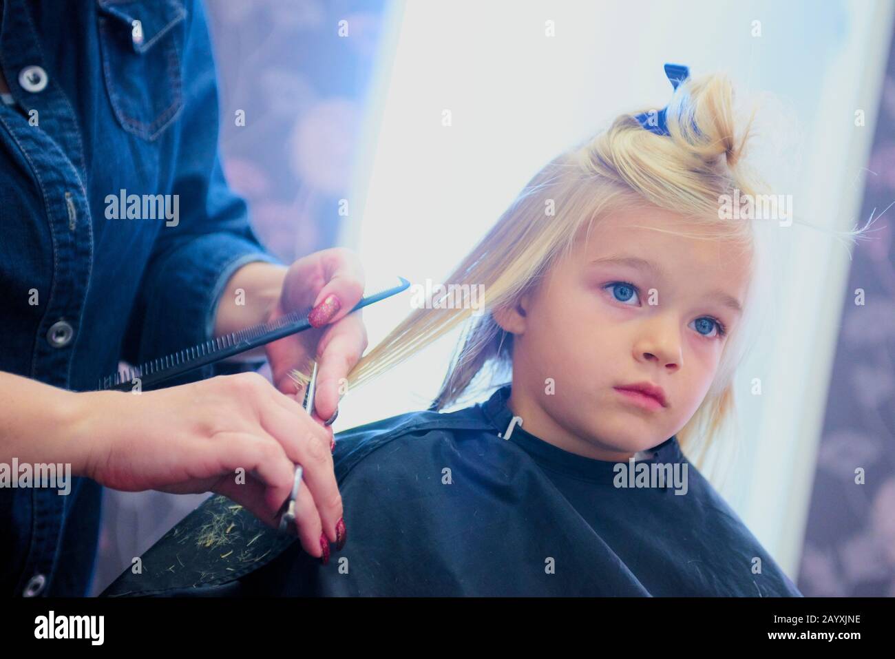 Petite fille mignonne dans le salon de coiffure. Mise au point sélective Banque D'Images