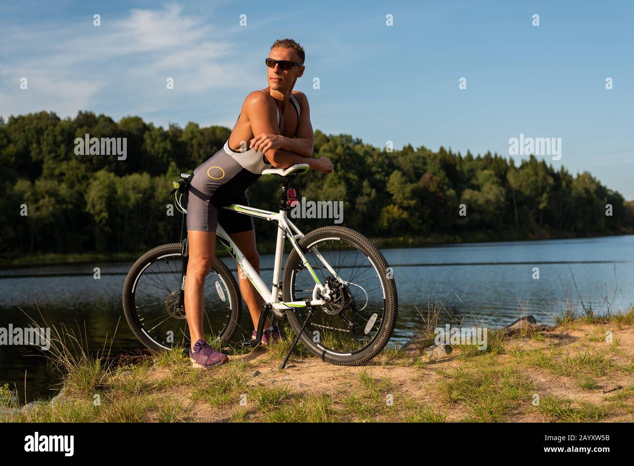 Une femme adulte à vélo, sur le bord d'un lac. Banque D'Images