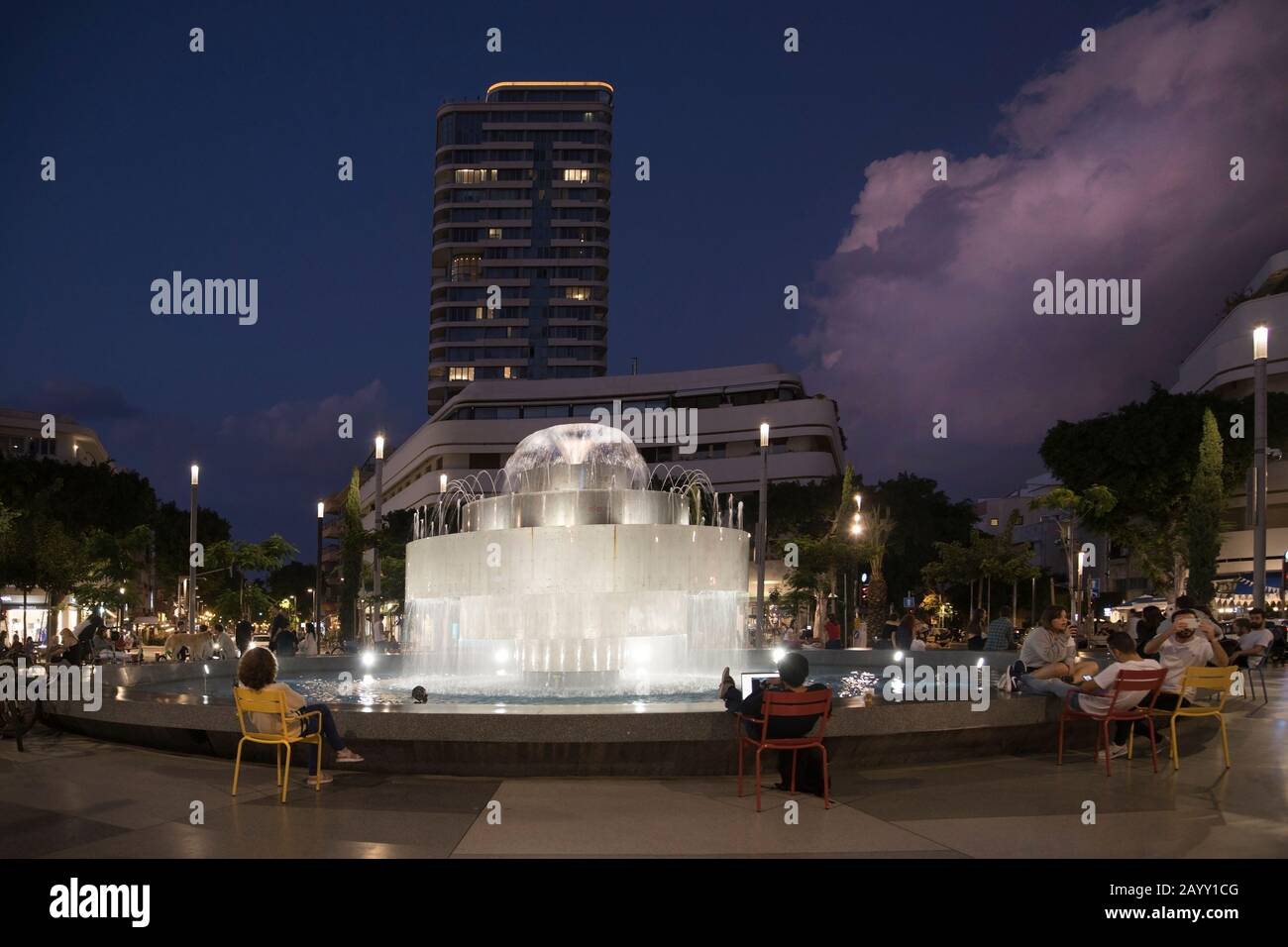 Les gens se détendent en soirée à la fontaine de la place Dizengoff sur la place publique récemment rénovée Banque D'Images