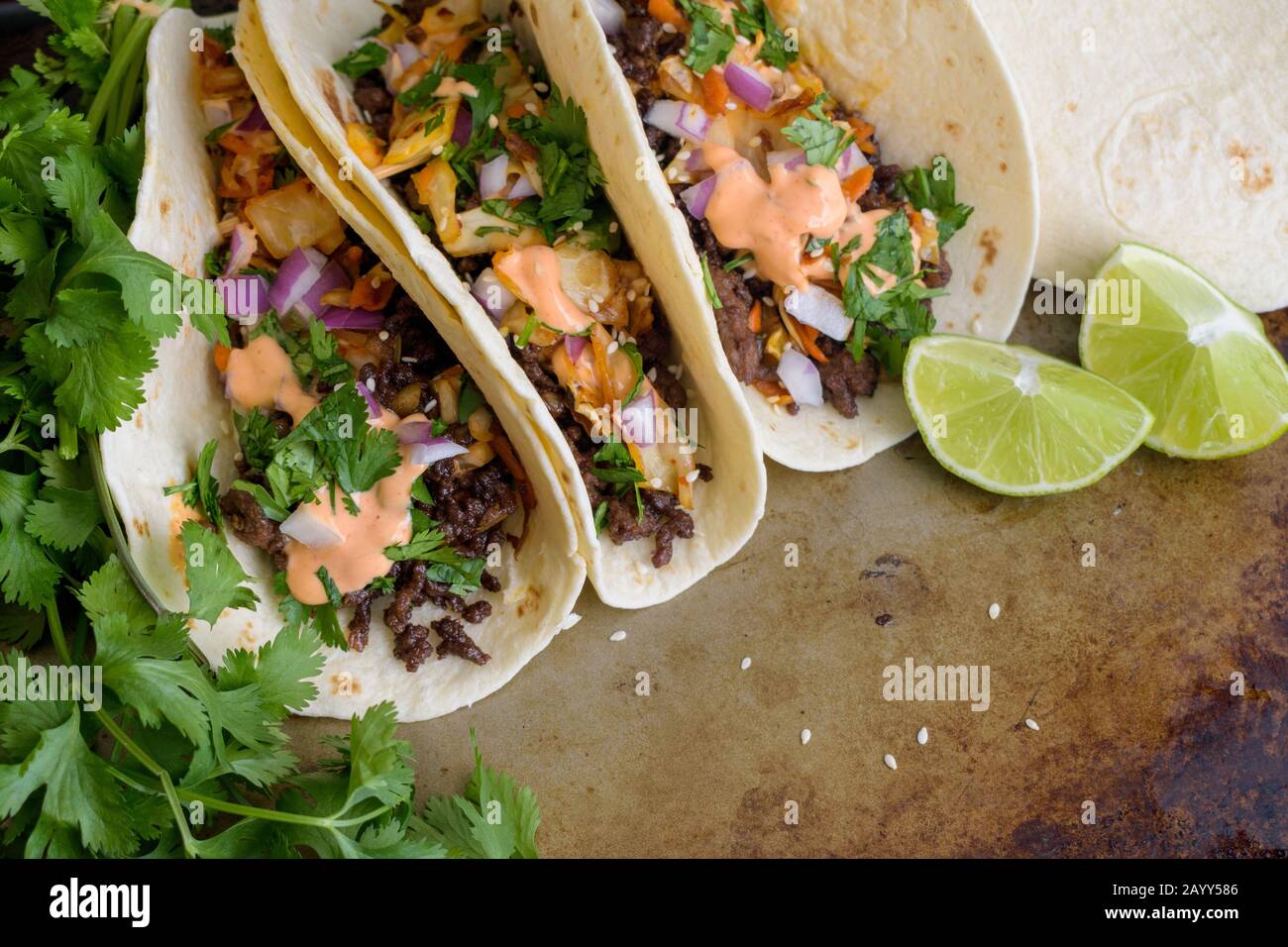 Tacos au bœuf coréen : cuisine fusion coréenne-mexicaine - Tacos faite de bœuf haché et surmontée de coriandre, kimchi et mayonnaise à la sriracha Banque D'Images