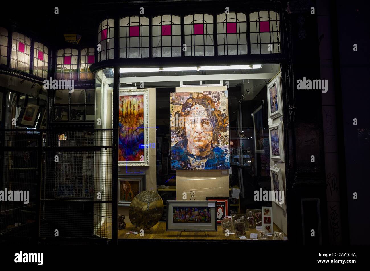 Un portrait de John Lennon à vendre dans une vitrine de magasin la nuit. Banque D'Images