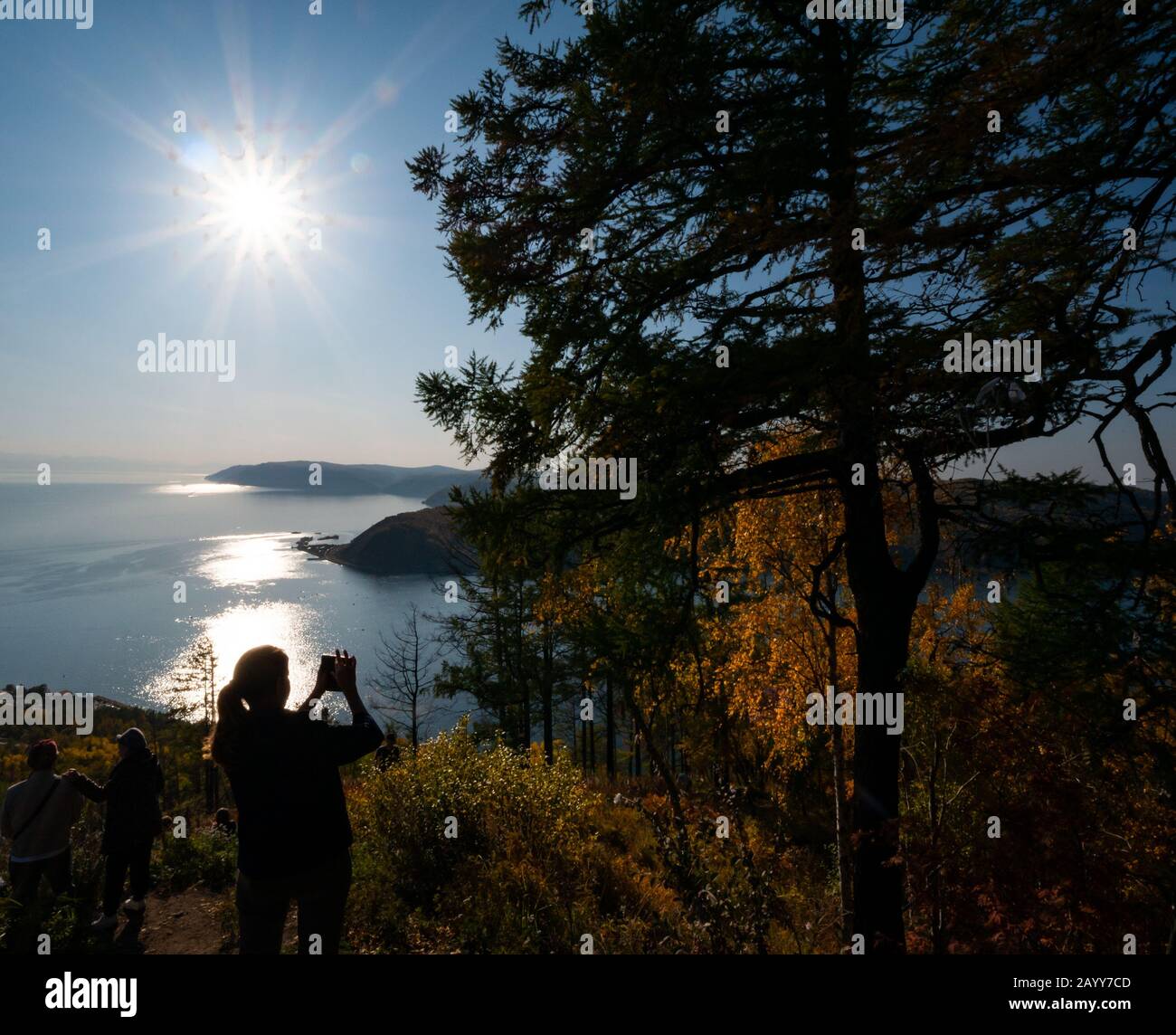 Lac Baikal de La pierre de Cherksy avec une femme prenant une photo, Listvyanak, région d'Irkoutsk, Sibérie, Russie Banque D'Images