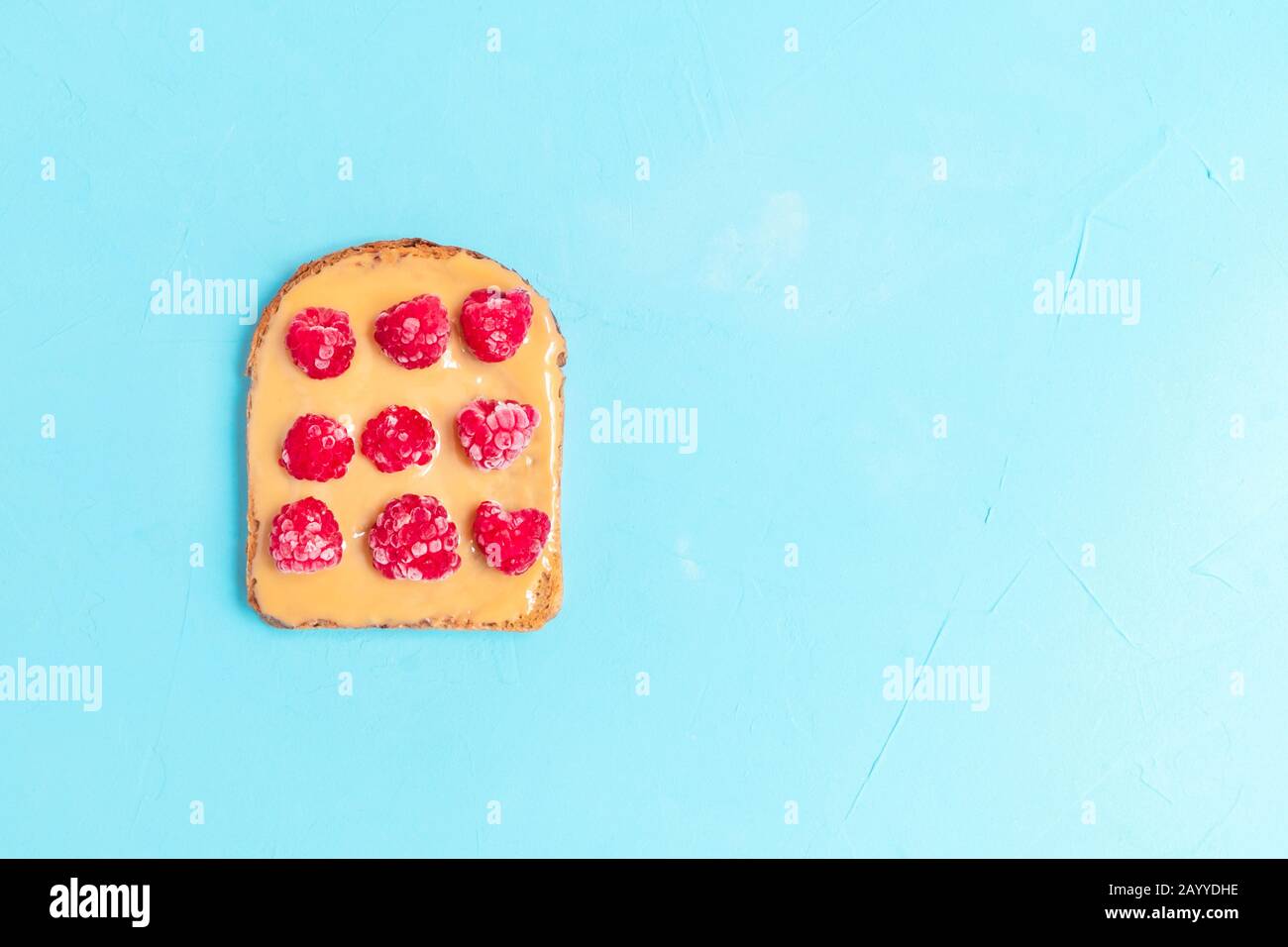 En-cas sain beurre d'arachide sandwich à la framboise sur fond bleu pastel. Vue de dessus avec espace de copie Banque D'Images