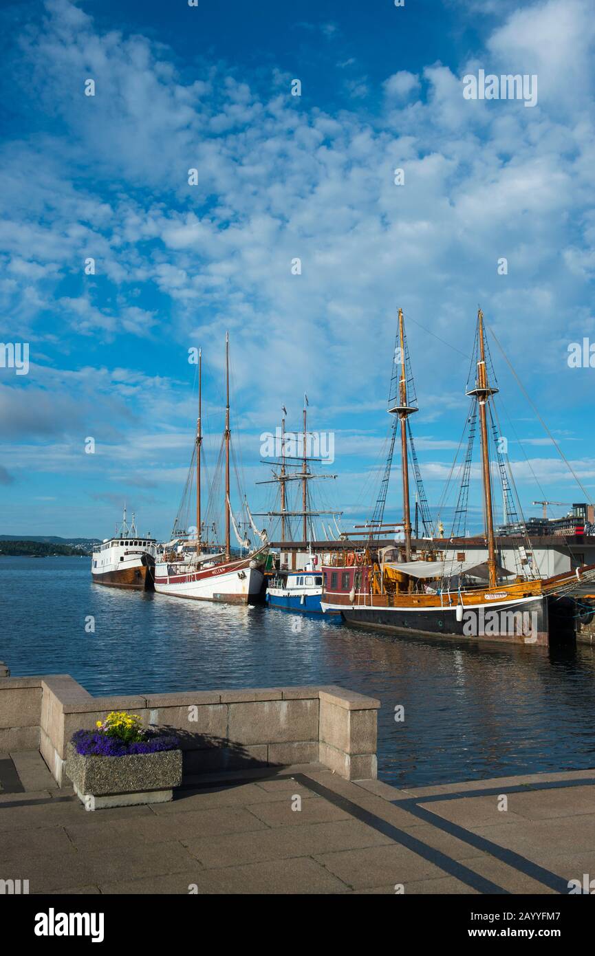 Vue sur les vieux bateaux à voile amarrés dans le port en face de l'hôtel de ville d'Oslo, Norvège. Banque D'Images