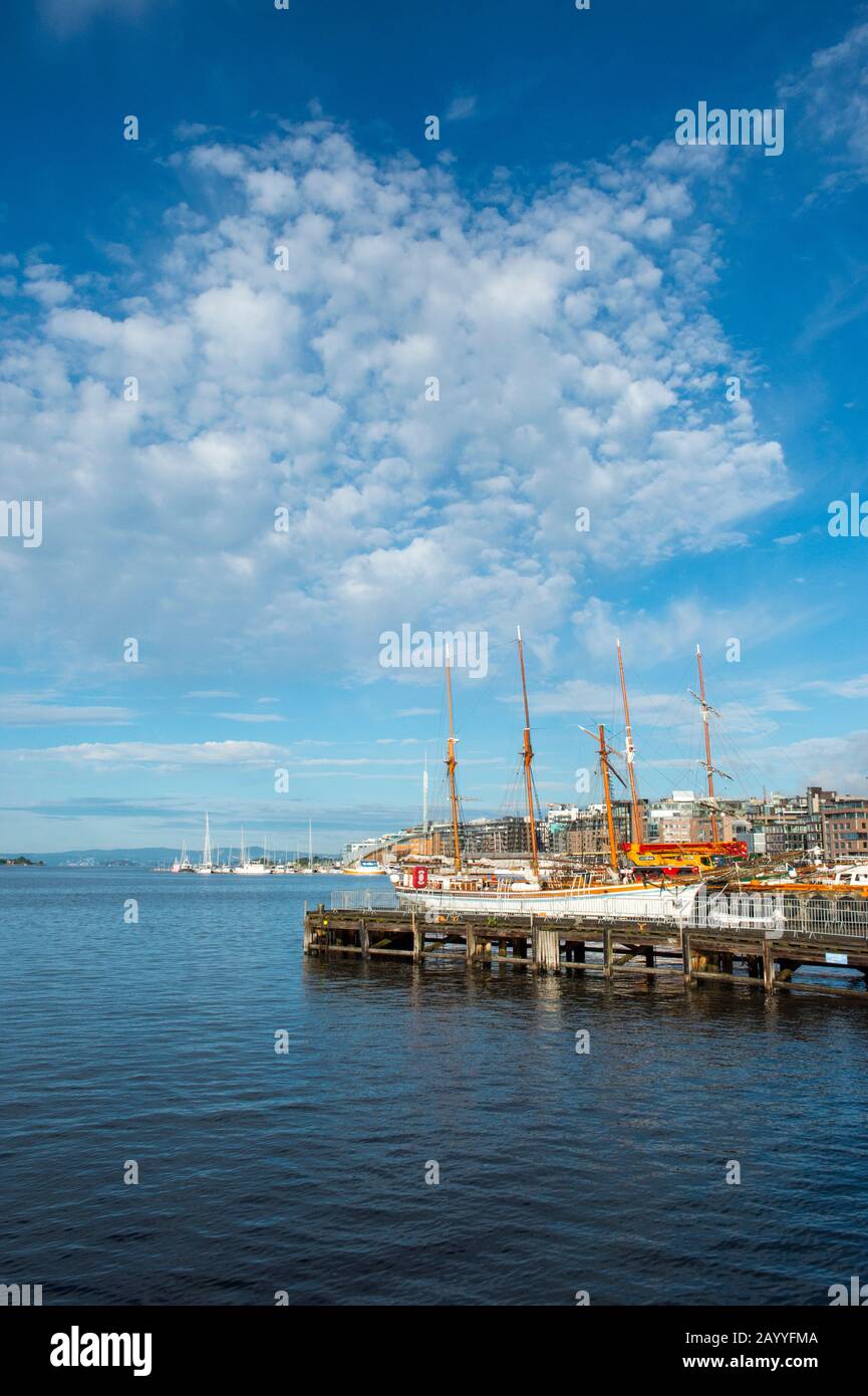 Vue sur les vieux bateaux à voile amarrés dans le port en face de l'hôtel de ville d'Oslo, Norvège. Banque D'Images