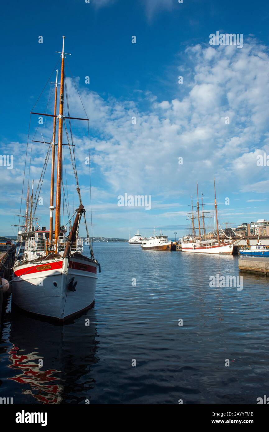 Vue sur les vieux bateaux à voile amarrés dans le port en face de l'hôtel de ville d'Oslo, Norvège. Banque D'Images