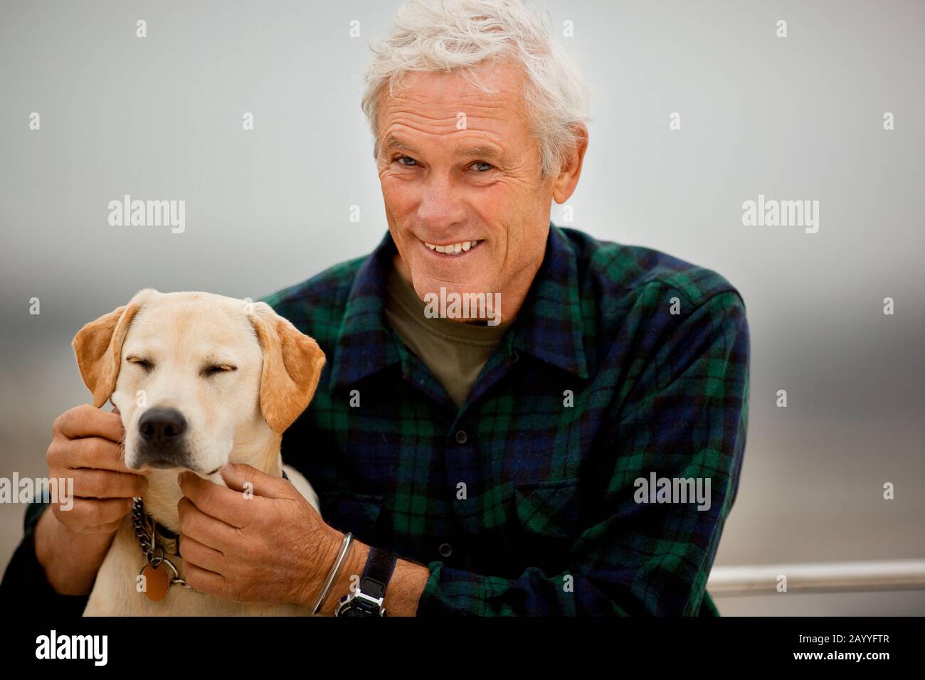 Détente homme avec son chien sur le pont d'un bateau. Banque D'Images