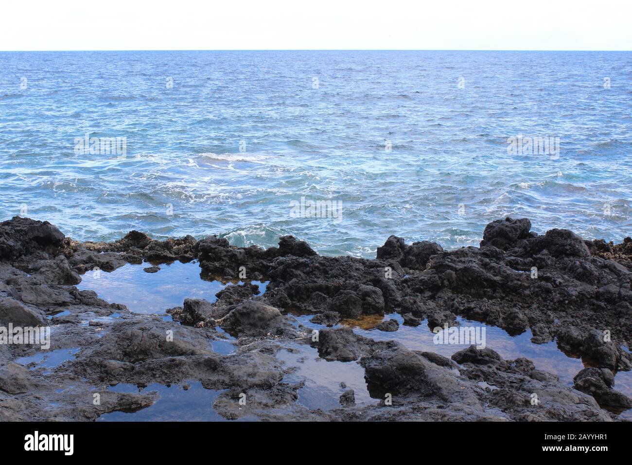 Rocas con pequeñas lagunas con reflejos, mar mediterráneo, Lanzarote, Islas Canarias. Banque D'Images