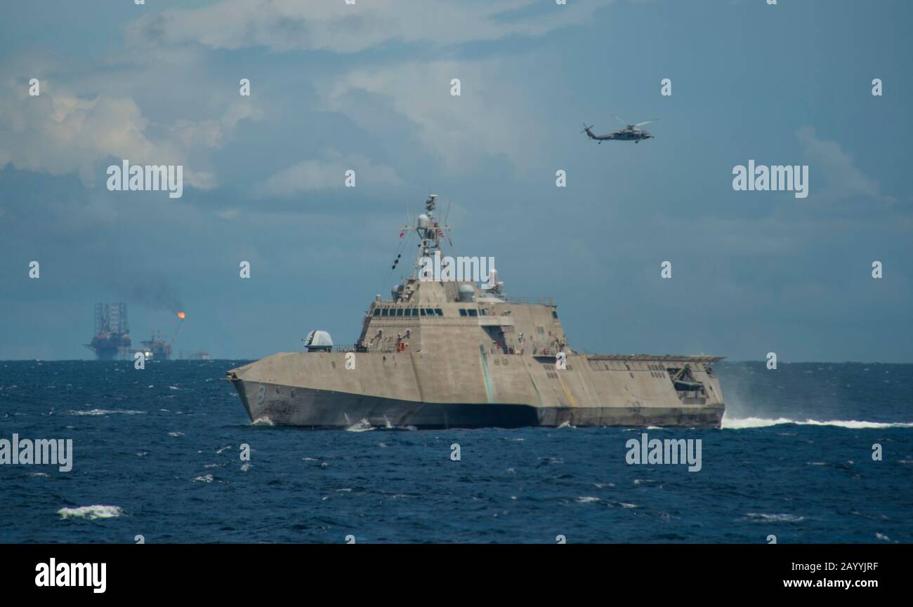 Un hélicoptère Sea Hawk de la marine américaine MH-60 vole au-delà du navire de combat littoral de la variante Independence USS Montgomery lors de la préparation et de la formation De la coopération À Flot le 31 octobre 2019 dans la baie de Brunei, au Brunei. Banque D'Images