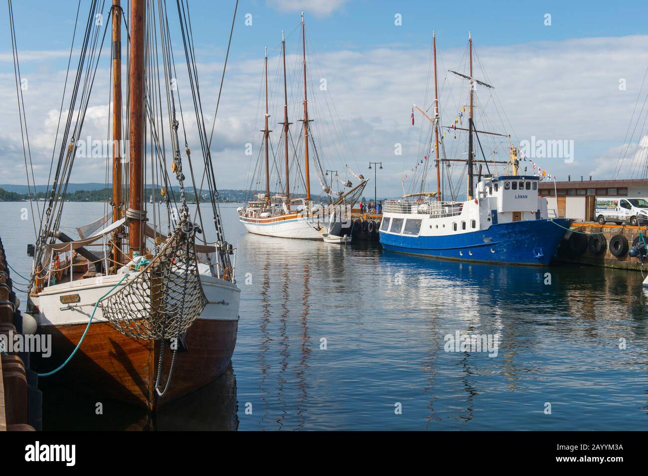 Vue sur les vieux bateaux à voile amarrés dans le port en face de l'hôtel de ville d'Oslo, Norvège. Banque D'Images