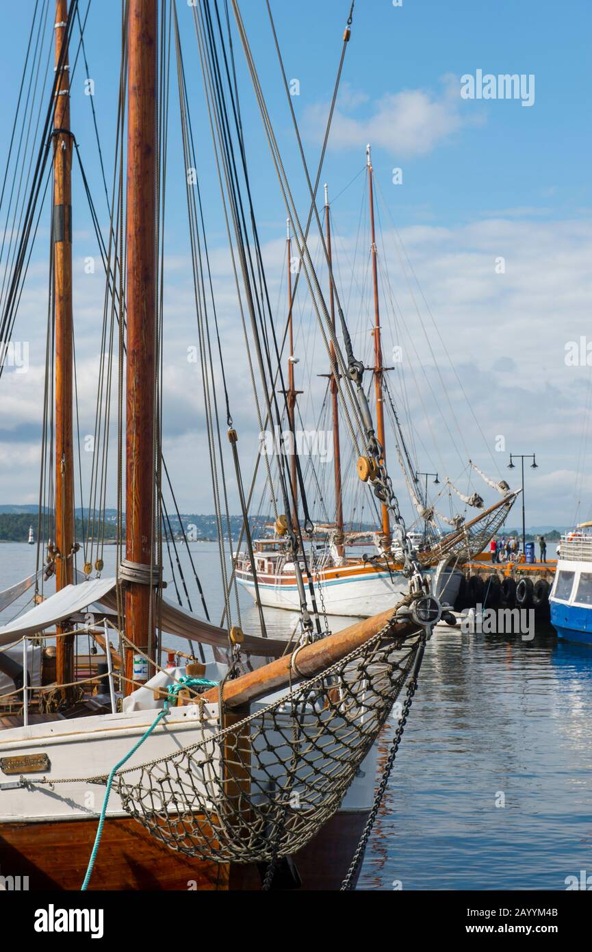 Vue sur les vieux bateaux à voile amarrés dans le port en face de l'hôtel de ville d'Oslo, Norvège. Banque D'Images