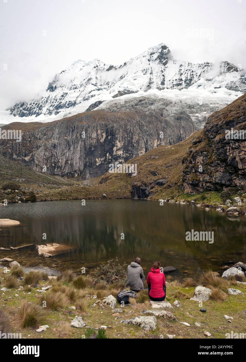 Couple assis à côté d'un lac sur la Laguna 69 randonnée dans les montagnes de la Cordillera Blanca dans le nord du Pérou. Banque D'Images