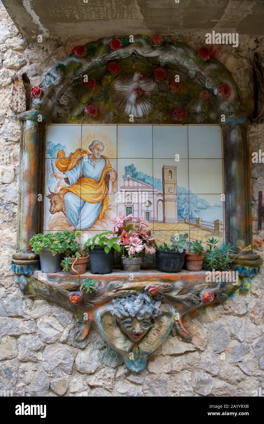 Tuiles avec motif religieux sur le mur d'une maison à Praiano qui est une ville construite sur une colline abrupte dans la province de Salerne dans le regi Campanie Banque D'Images