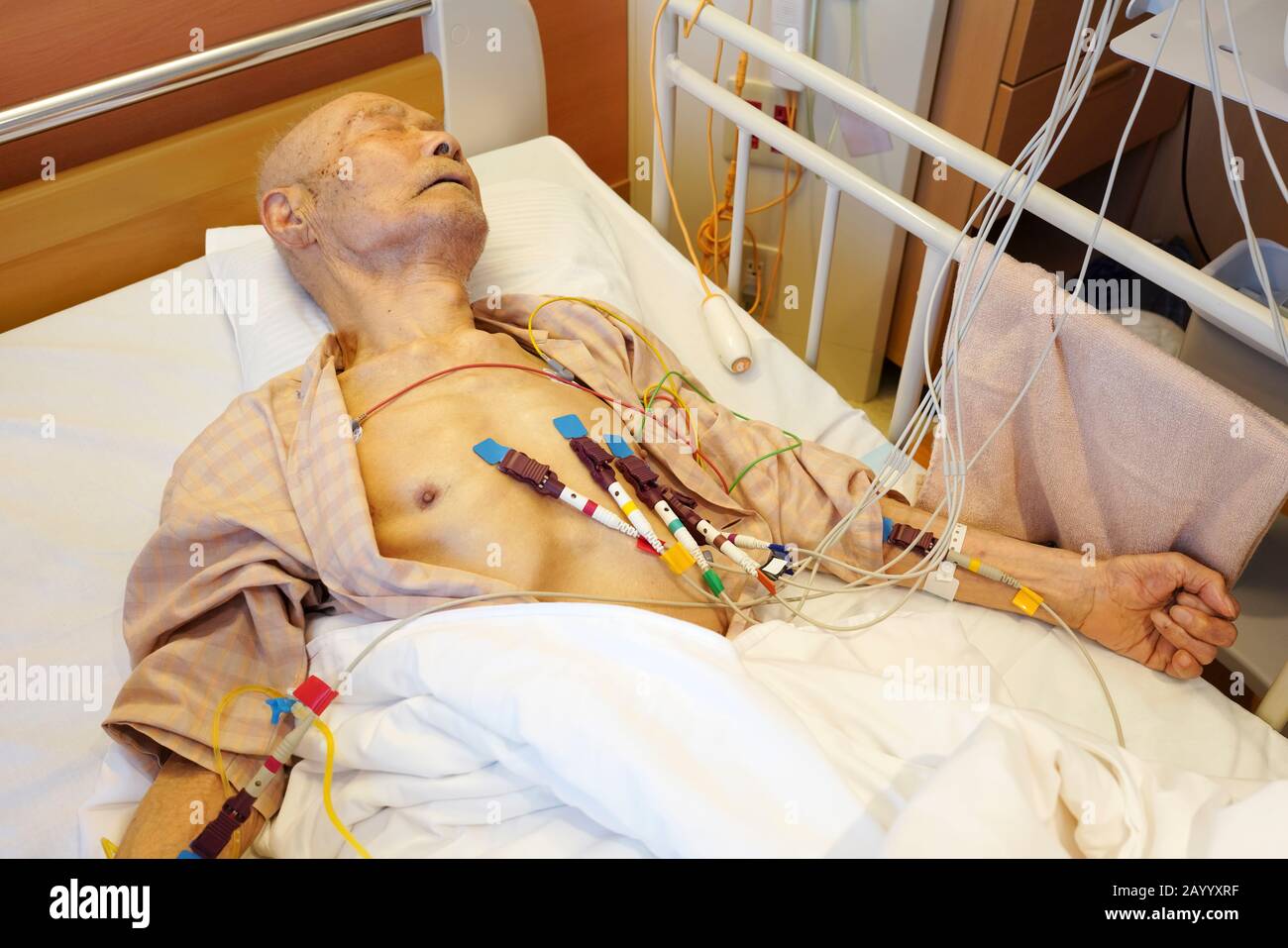 Un vieil homme japonais allongé sur le lit, prenez un cardiogramme à l'hôpital Banque D'Images