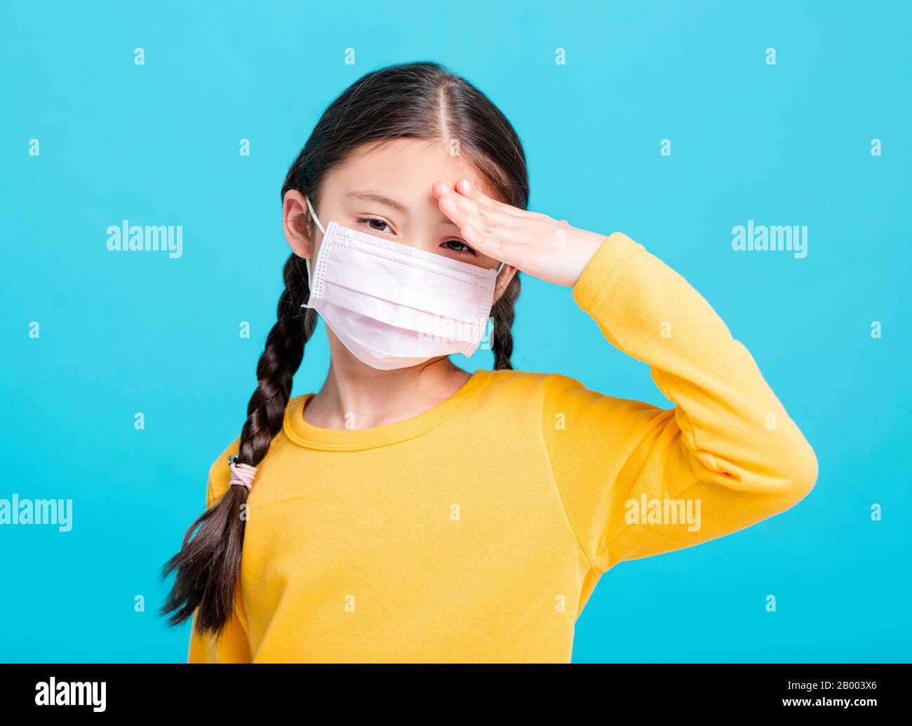 Enfant malade fille dans le masque médical isolé sur fond bleu Banque D'Images