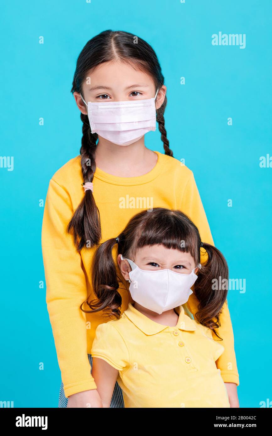 Les filles malades dans le masque médical isolé sur fond bleu Banque D'Images