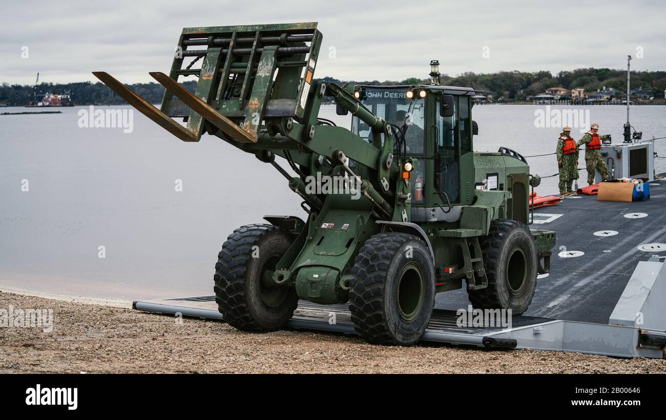 Un marine américain avec 2 d Marine Logistics Group décharge un tracteur de la lumière qui a été transporté par Des Marins américains de l'USNS 1ère Lt Baldomero Lopez (T-AK 3010) à Marine corps support Facility Blount Island, 12 février 2020 pendant l'exercice de force de prépositionnement maritime (MPFEX) 20. La légèreté permet de faire le transport de marchandises vers le rivage dans les zones où les ports sont inexistants ou en mauvais état et donne aux forces militaires du pays la capacité d'opérer dans les zones développées et non développées du monde. MPFEX 20 est un exercice militaire dans lequel les marines et Les Marins ont travaillé ensemble pour le déchargement et la proc Banque D'Images