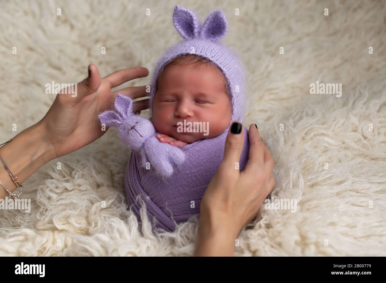 Femme mains s'occuper d'un bébé nouveau-né. Photographe et son enfant. Concept pour la prise de vue de bébé, la famille, les soins et la naissance Banque D'Images