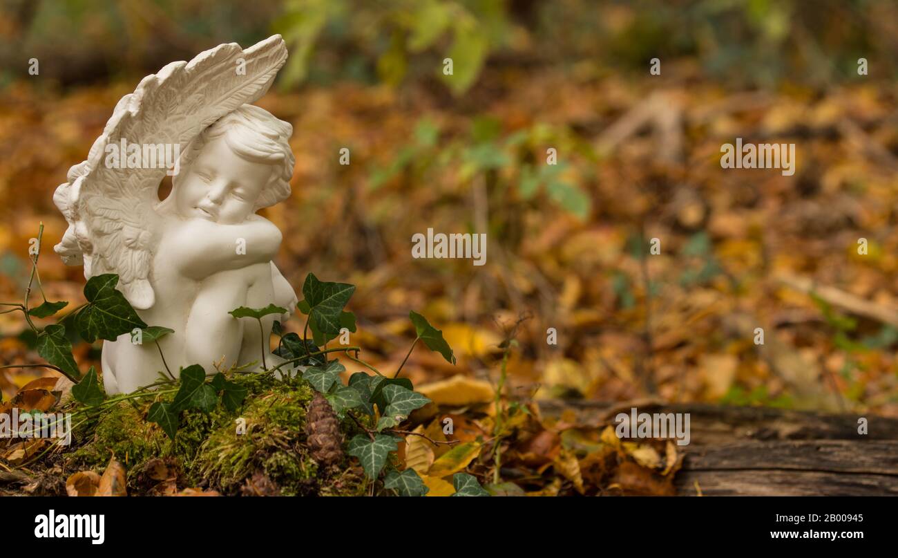 Ange avec bougie dans le cimetière de la forêt Banque D'Images