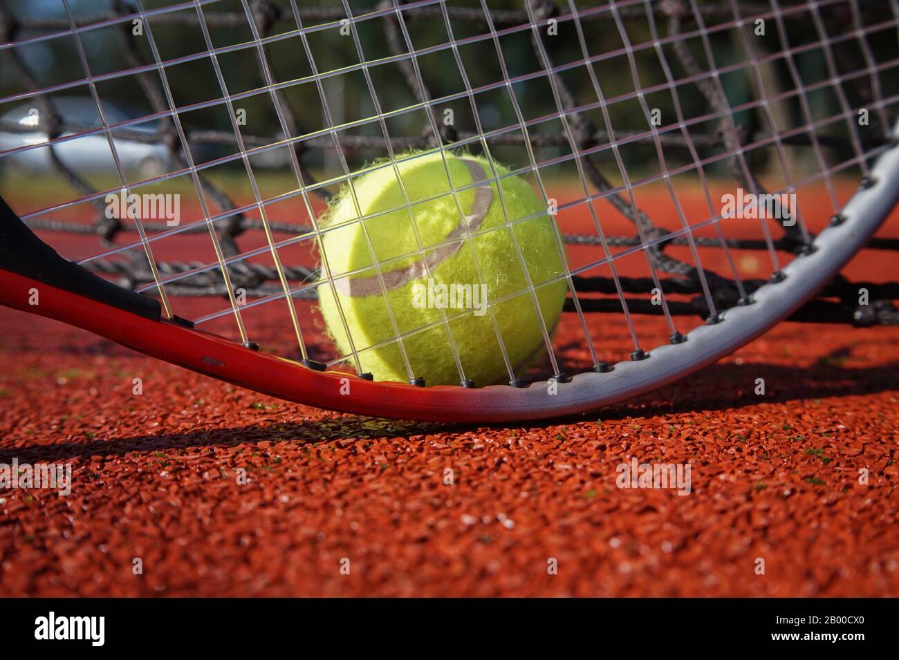 Balle de Tennis, raquette et de ligne sur une cour extérieure avec la raquette standing on end jette une ombre sur la surface de tous les temps Banque D'Images