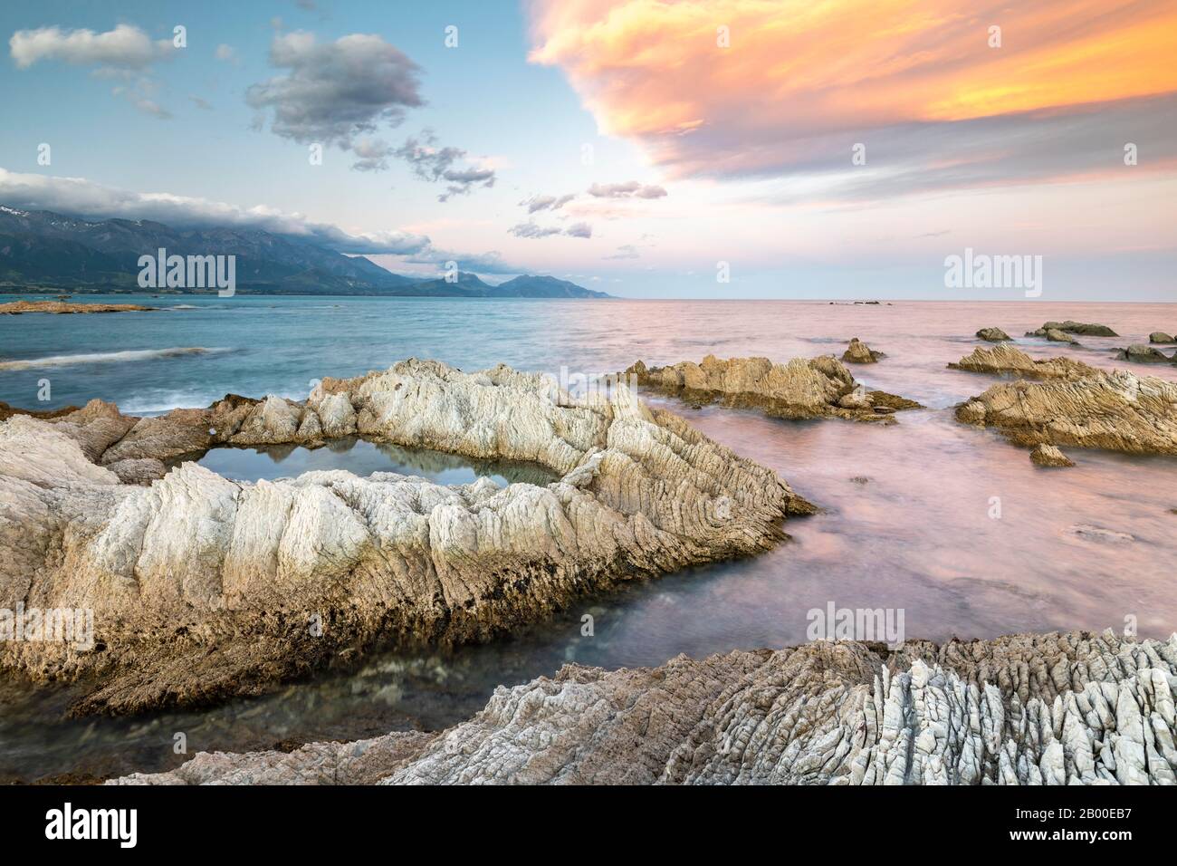 Côte rocheuse sur la péninsule de Kaikoura, montagnes de la chaîne de Kaikoura en arrière-plan, Kaikoura, Canterbury, île du Sud, Nouvelle-Zélande Banque D'Images