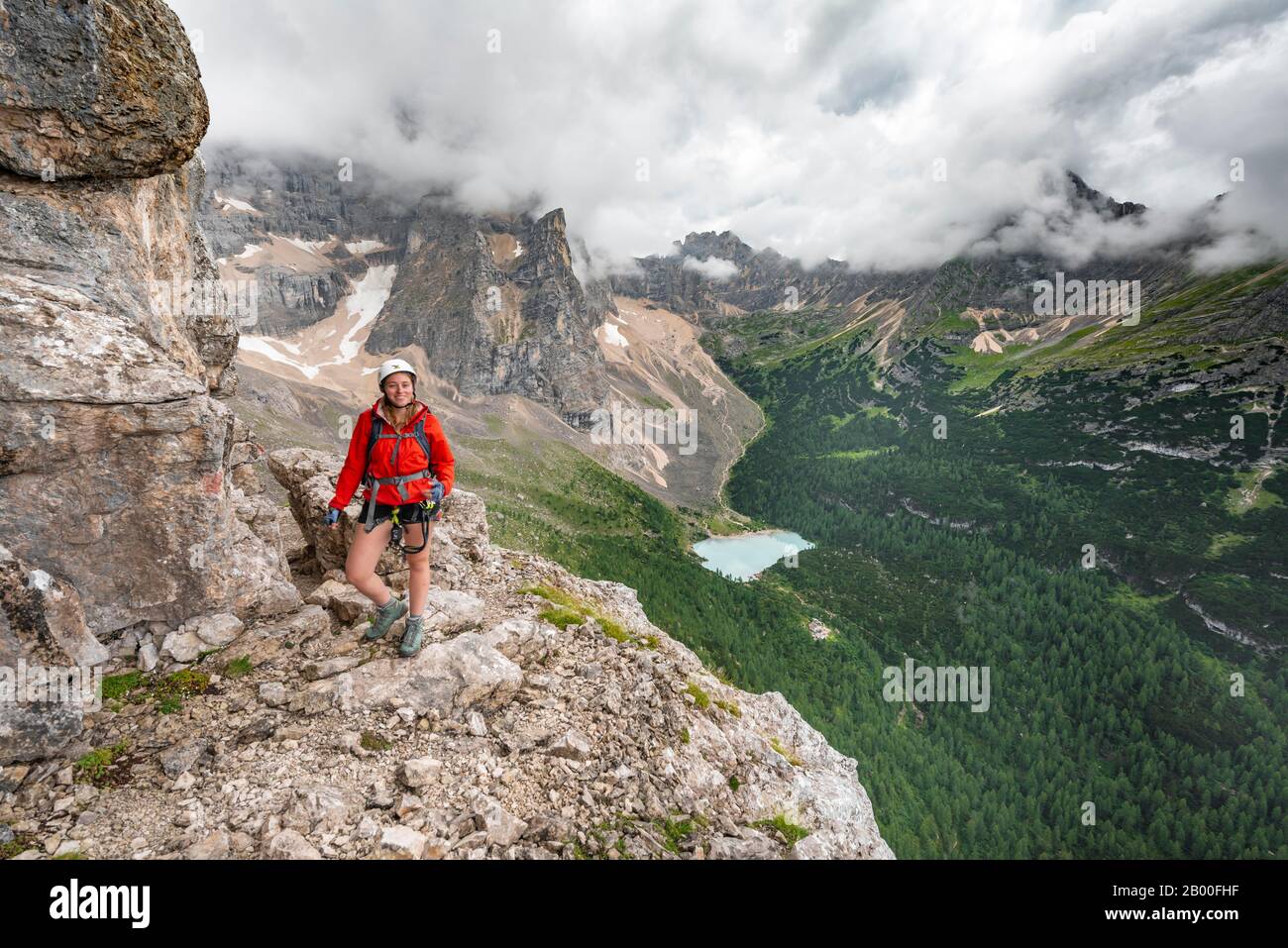 Jeune femme, randonneur sur une corde fixe, Via ferrata Vandelli, Sorapiss circuit, montagnes à faible nuage, Dolomites, Belluno, Italie Banque D'Images