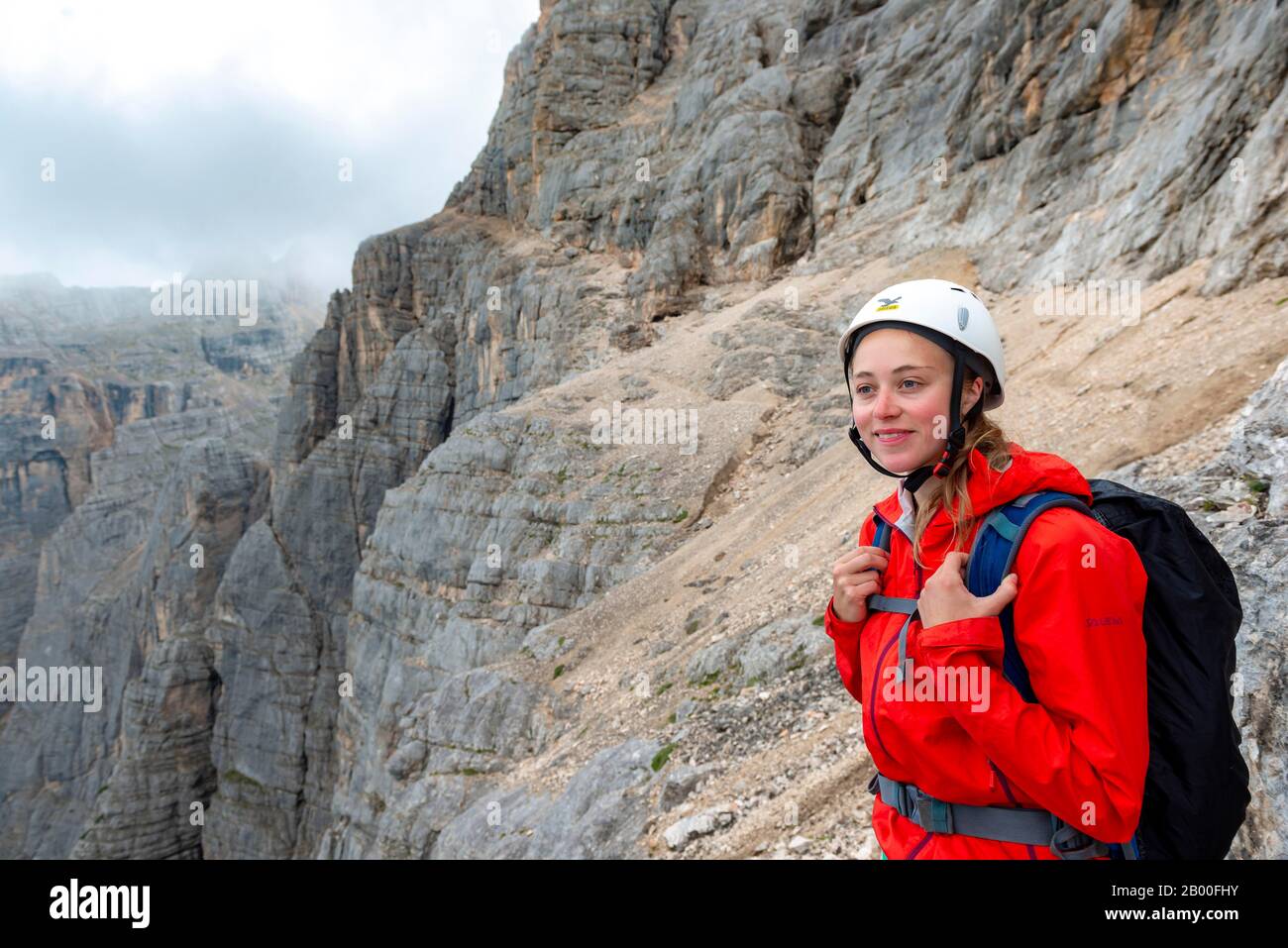 Jeune femme, randonneur avec casque d'escalade devant un rocher, Via ferrata Francesco Berti, Sorapiss circuit, Dolomites, Belluno, Italie Banque D'Images