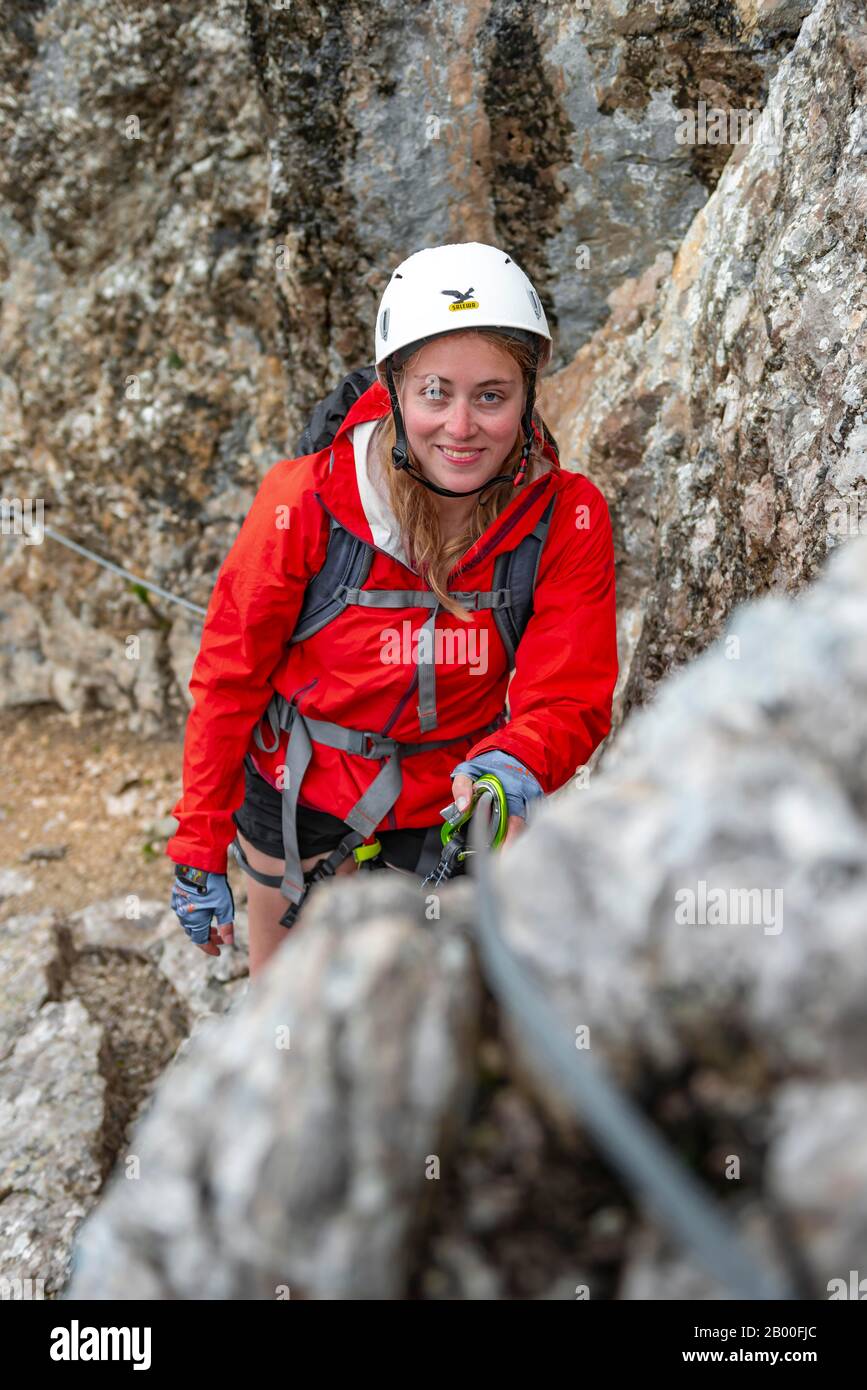 Jeune femme, randonneur escalade A via ferrata Vandelli, Sorapiss circuit, Dolomites, Belluno, Italie Banque D'Images
