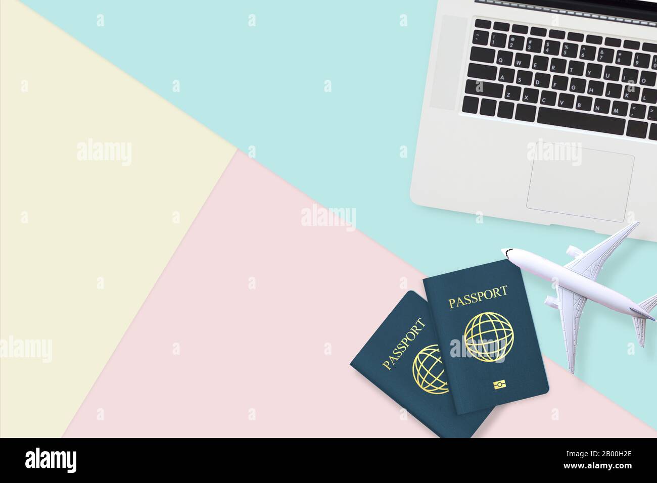couche plate de passeport, modèle d'avion blanc et ordinateur portable sur fond bleu pastel, jaune et rose avec espace de copie. voyage, visa et vacances Banque D'Images