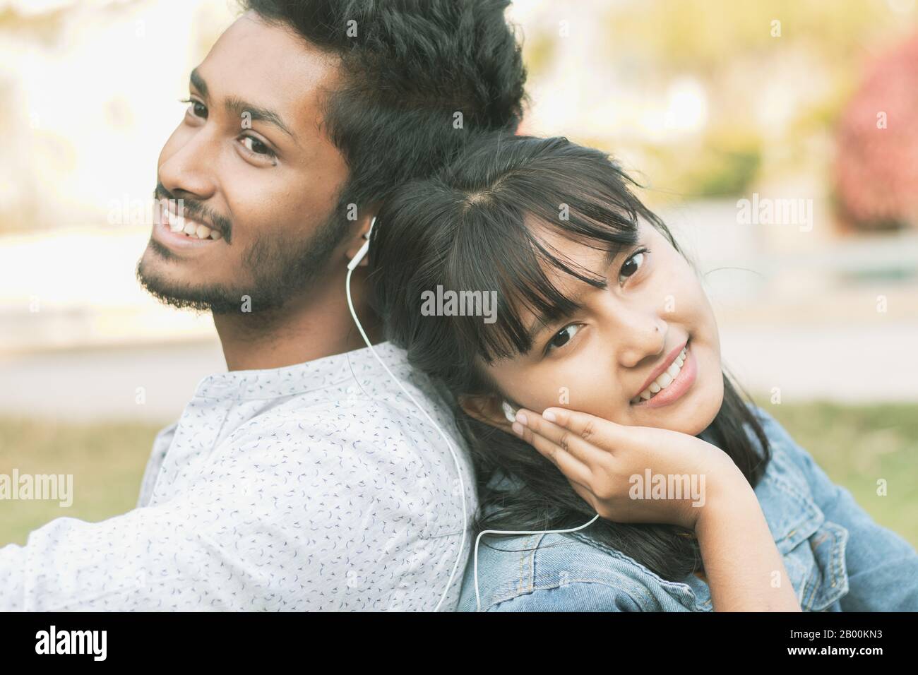 Les jeunes adolescents qui aiment écouter la chanson ou la musique préférée en Se Reposant de retour - concept de couple relaxant, pique-nique dans le parc, Amour, datant Banque D'Images