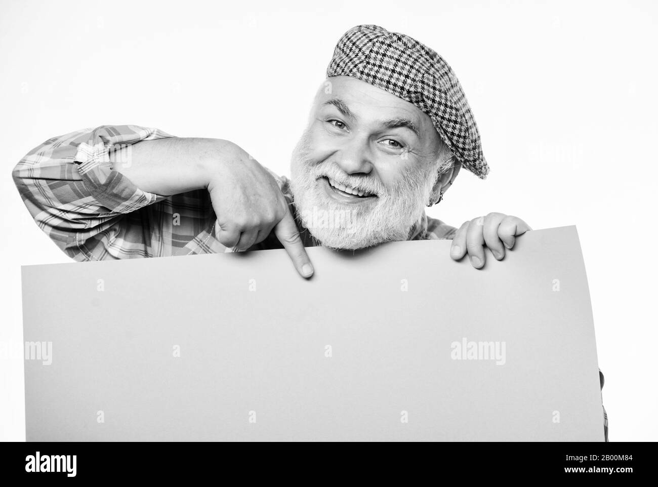 Heureux homme mûr en rétro hat. Publicité. Homme barbu Senior place annonce sur bannière. recherche d'emploi. Besoin d'aide. voulait. Copie espace apaiser l'information. présentateur de votre annonce. Banque D'Images