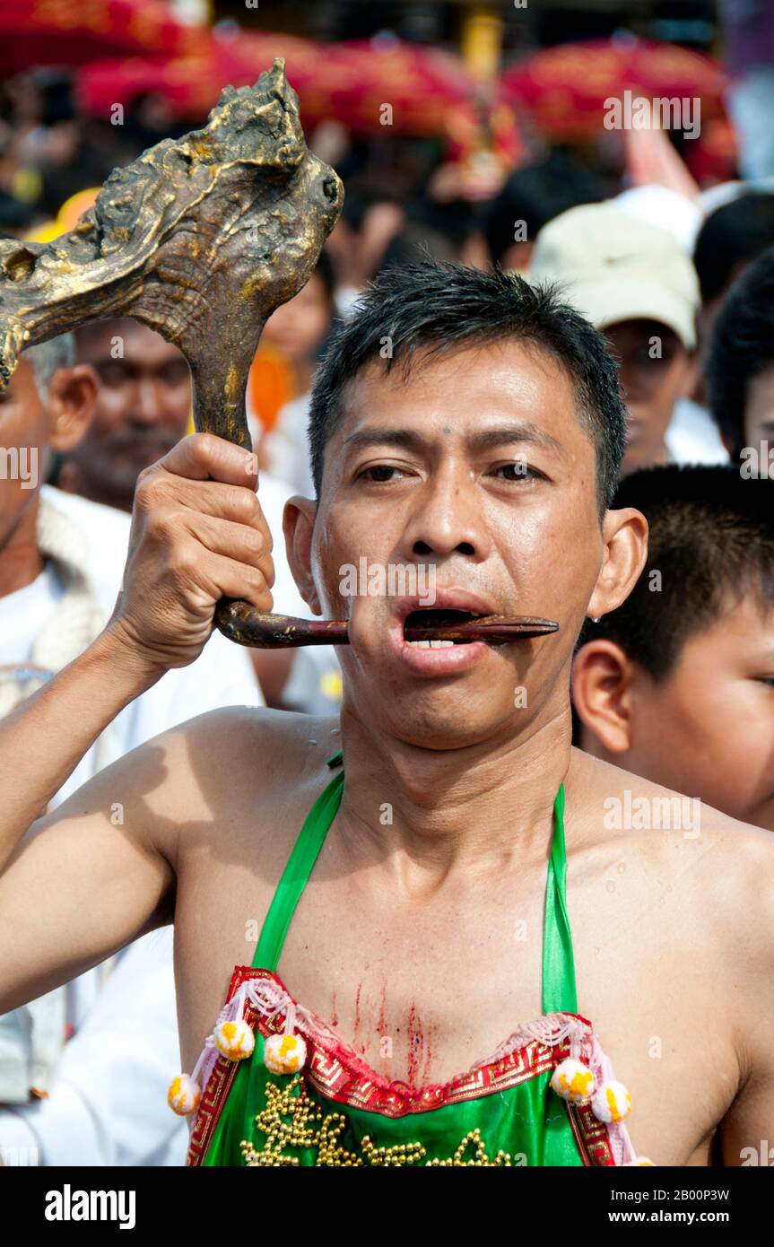 Thaïlande: Le dévot ou 'ma Song' participe à une procession à travers la ville de Phuket, Festival végétarien de Phuket. Le Festival végétarien est un festival religieux qui se tient chaque année sur l'île de Phuket dans le sud de la Thaïlande. Il attire des foules de spectateurs en raison de nombreux rituels religieux inhabituels qui sont exécutés. Beaucoup de dévotés religieux se slaleront avec des épées, perce leurs joues avec des objets pointus et commettent d'autres actes douloureux. Banque D'Images